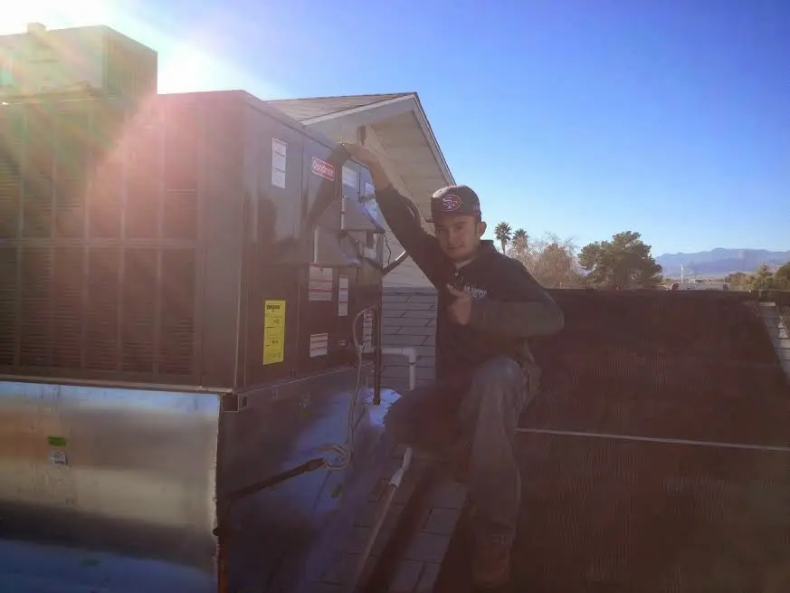 HVAC technician performing Air Duct Repair on a rooftop unit in Maidencreek